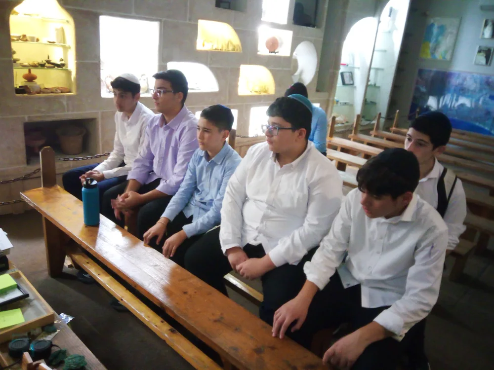 A group of talmidim listening during an educational outing